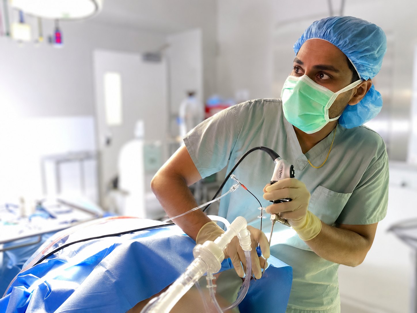 Dr. Jithin John in scrubs during ENT surgical training at Detroit Medical Center